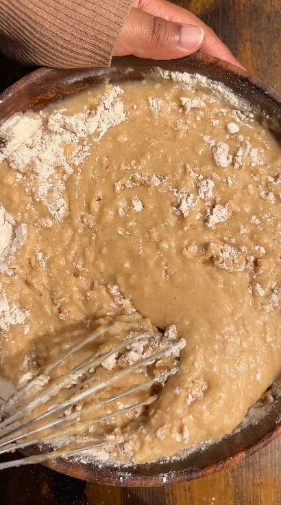 "Vegan coconut cake batter in a large mixing bowl, slightly lumpy texture"